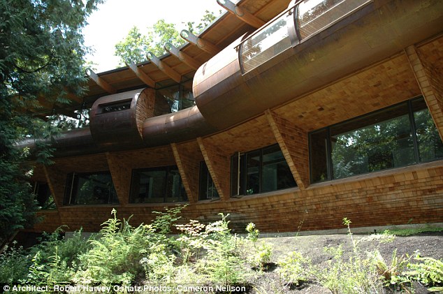 The exterior of the house is a series of horizontal layers featuring copper, cedar shingles, and a copper metal roof