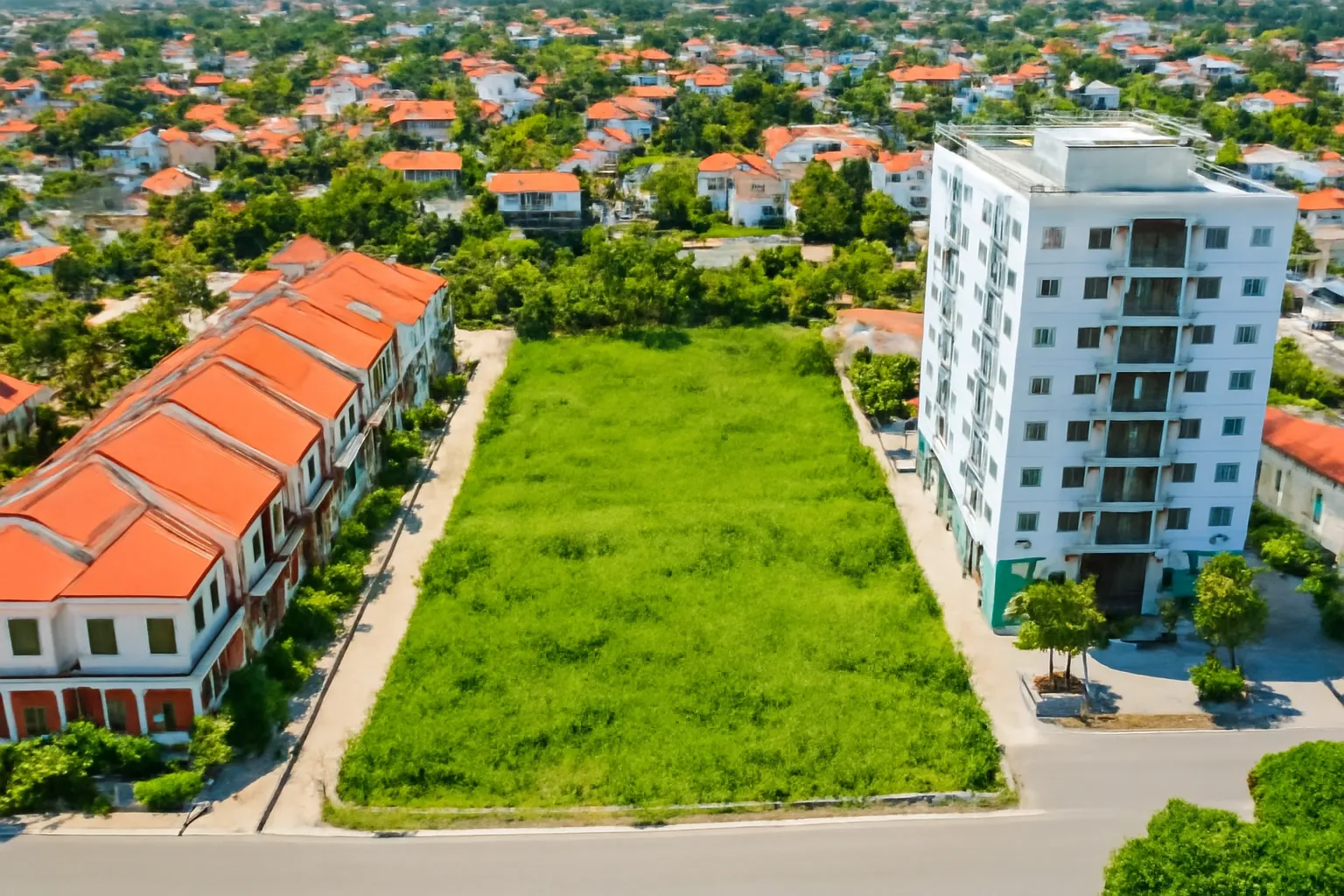 Toàn cảnh từ trên cao khu ven đô có nhà phố, chung cư và đất trống xanh